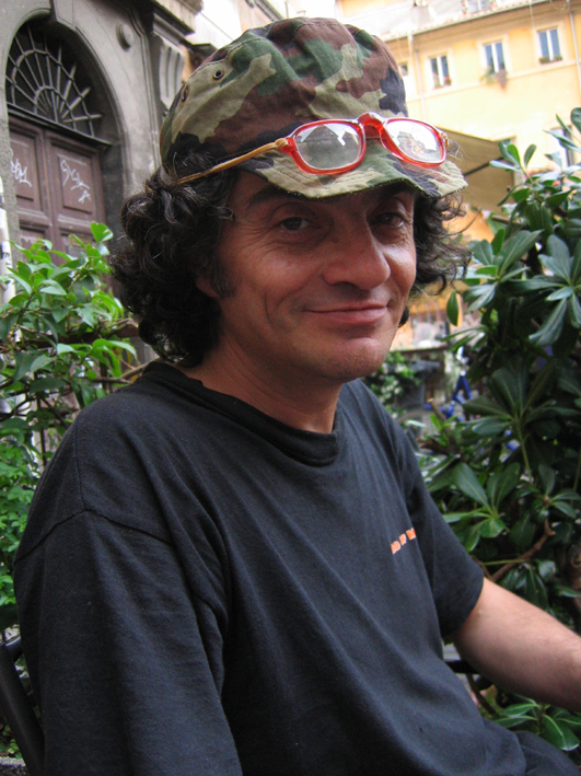 a man with sunglasses and a camo hat looks into the camera
