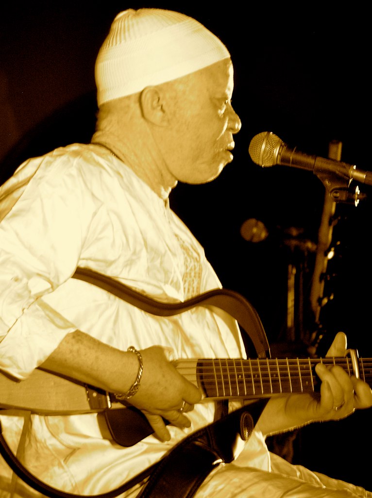 a man in a white hat playing a guitar