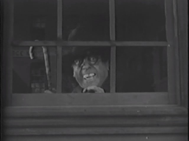 an older man looking out a window with a y face