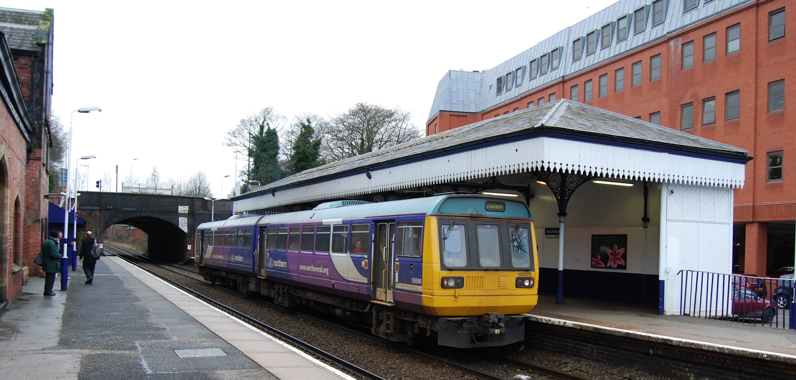 a train pulling into the station where a man waits