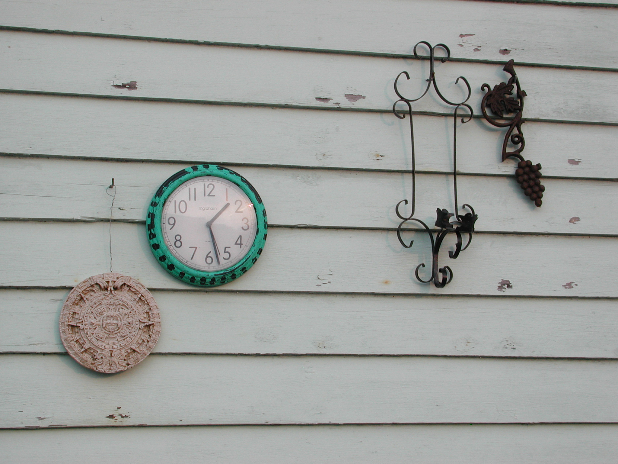 a clock, wirework, and some wall decorations on a house