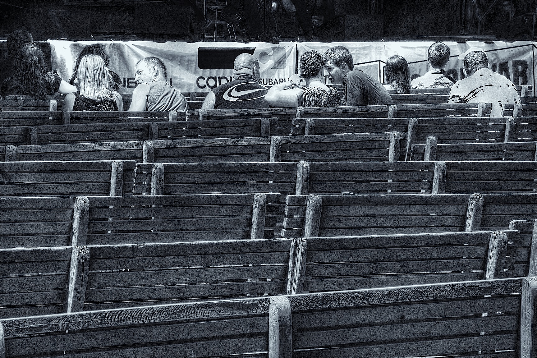 rows of empty seats in a stadium with a large banner hanging from the wall