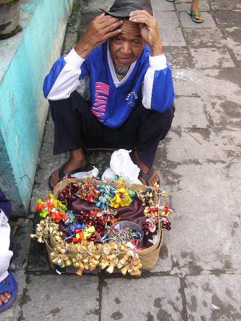 a man sitting on the steps with a pile of candy in his hand