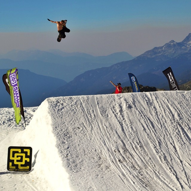 a snowboarder is in the air after jumping a slope