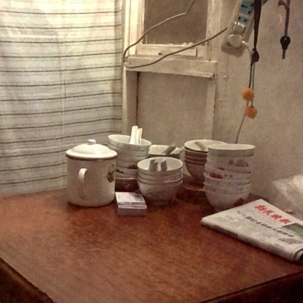 a small table with some ceramic cups and magazines on it
