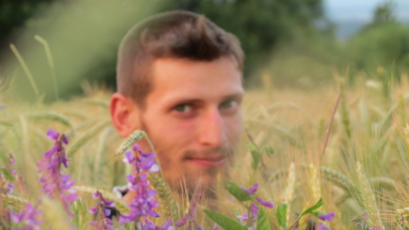 a man is sitting in the middle of tall grass