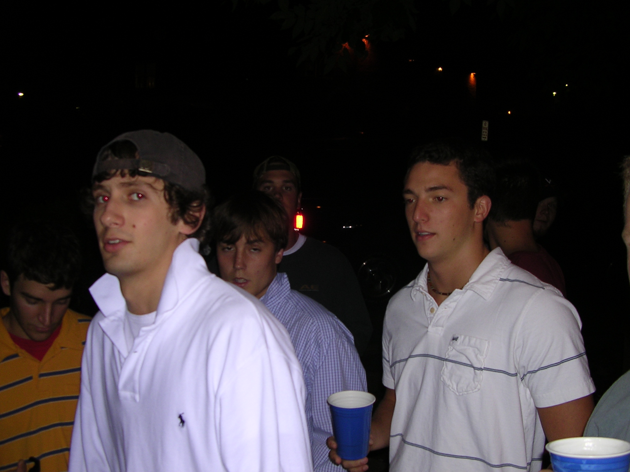 several men standing together with some drink in hand