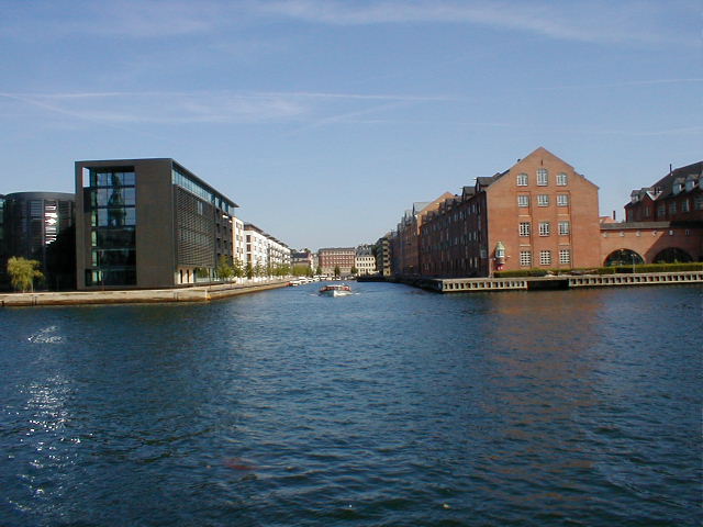 a river going through some buildings on a sunny day