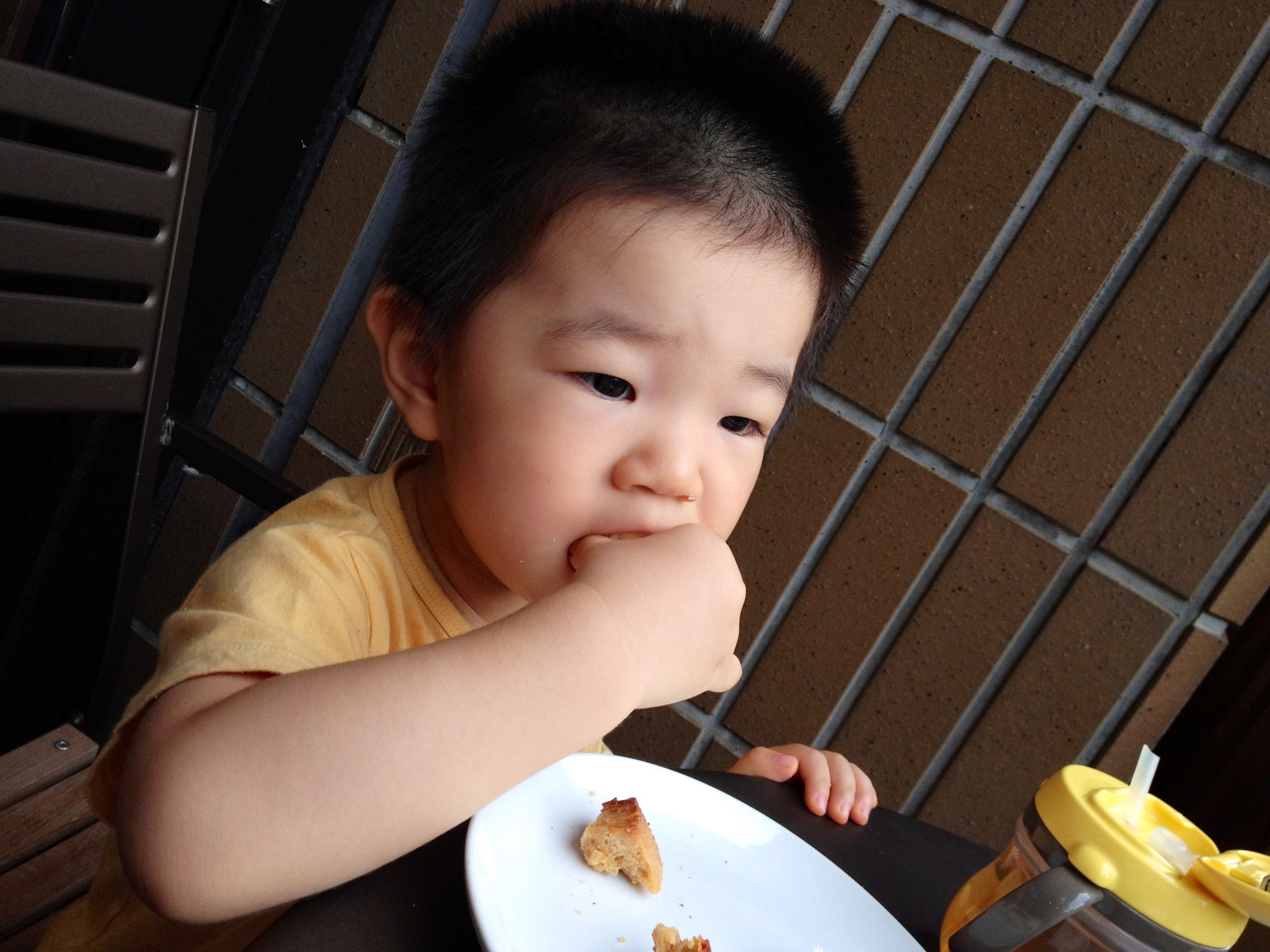 a little child sitting at a table with some food