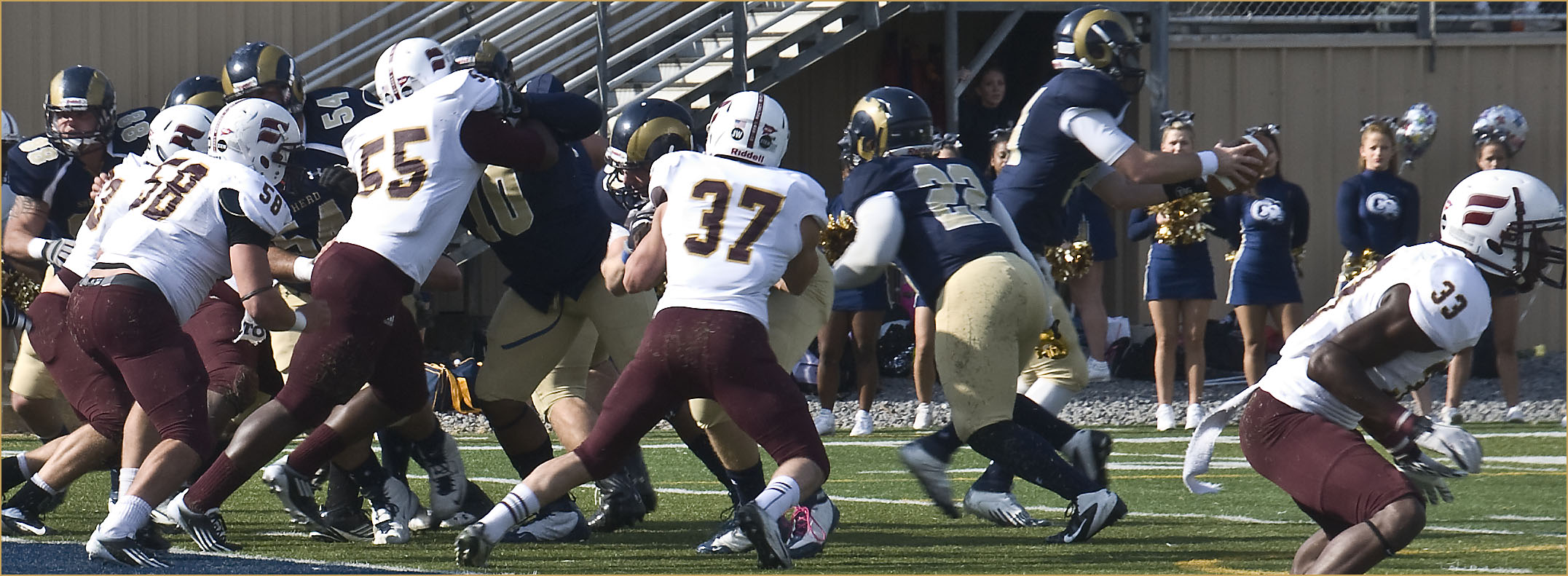 a football game between two opposing teams is on a grassy field