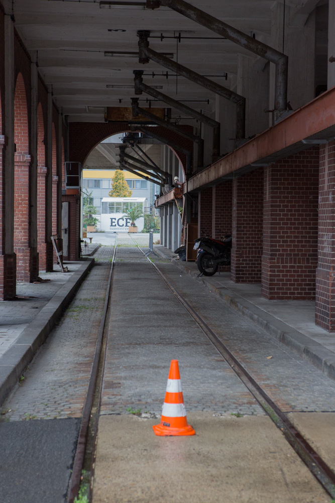 an orange cone on the floor near a train