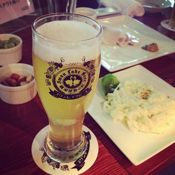 a glass of beer next to a plate of food