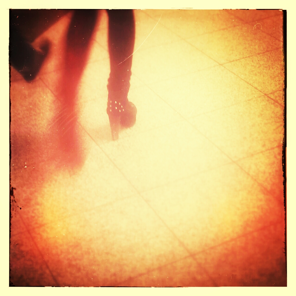 the legs and ankles of a woman on a tile floor