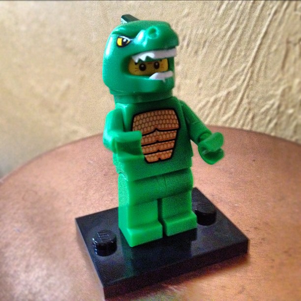 a green lego figure is displayed on a table