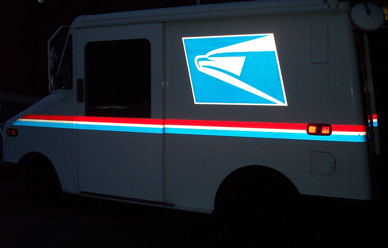 an mail delivery truck with a us postal office sticker on it's side