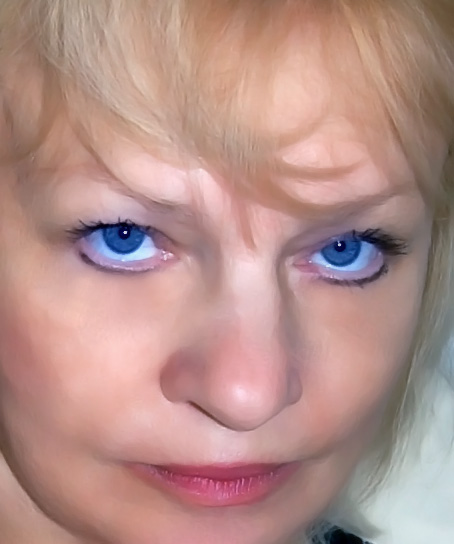 a woman with blue eyes and hair looks at the camera