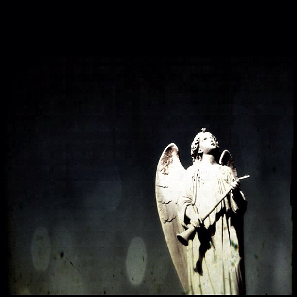 an angel sculpture is shown with a black background