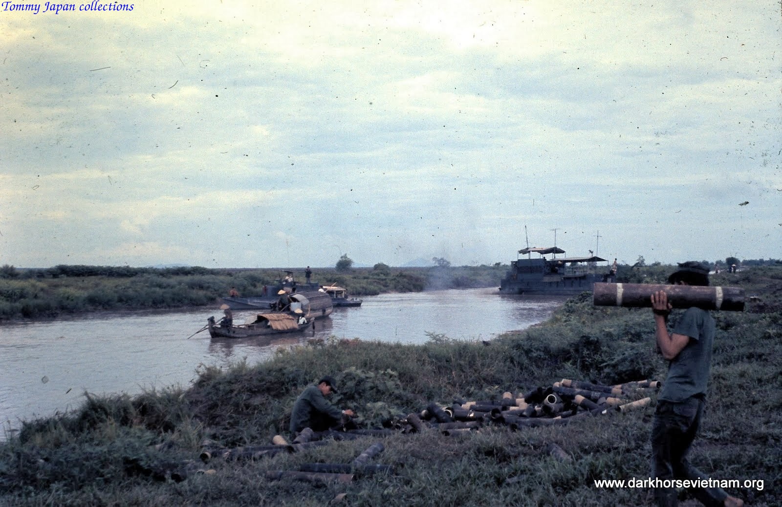 some men on a boat in water next to other boats