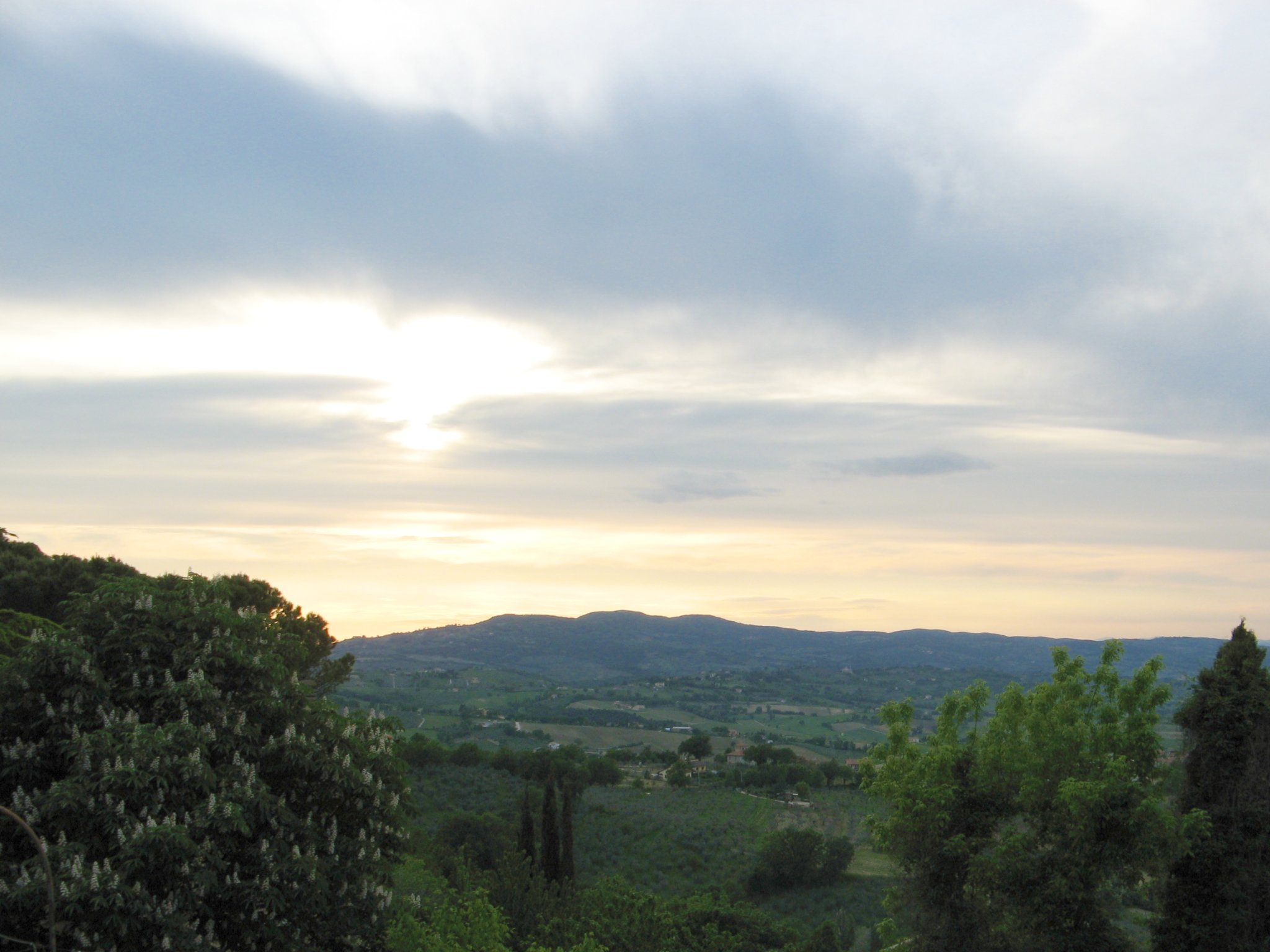 the sun setting over a valley and some mountains