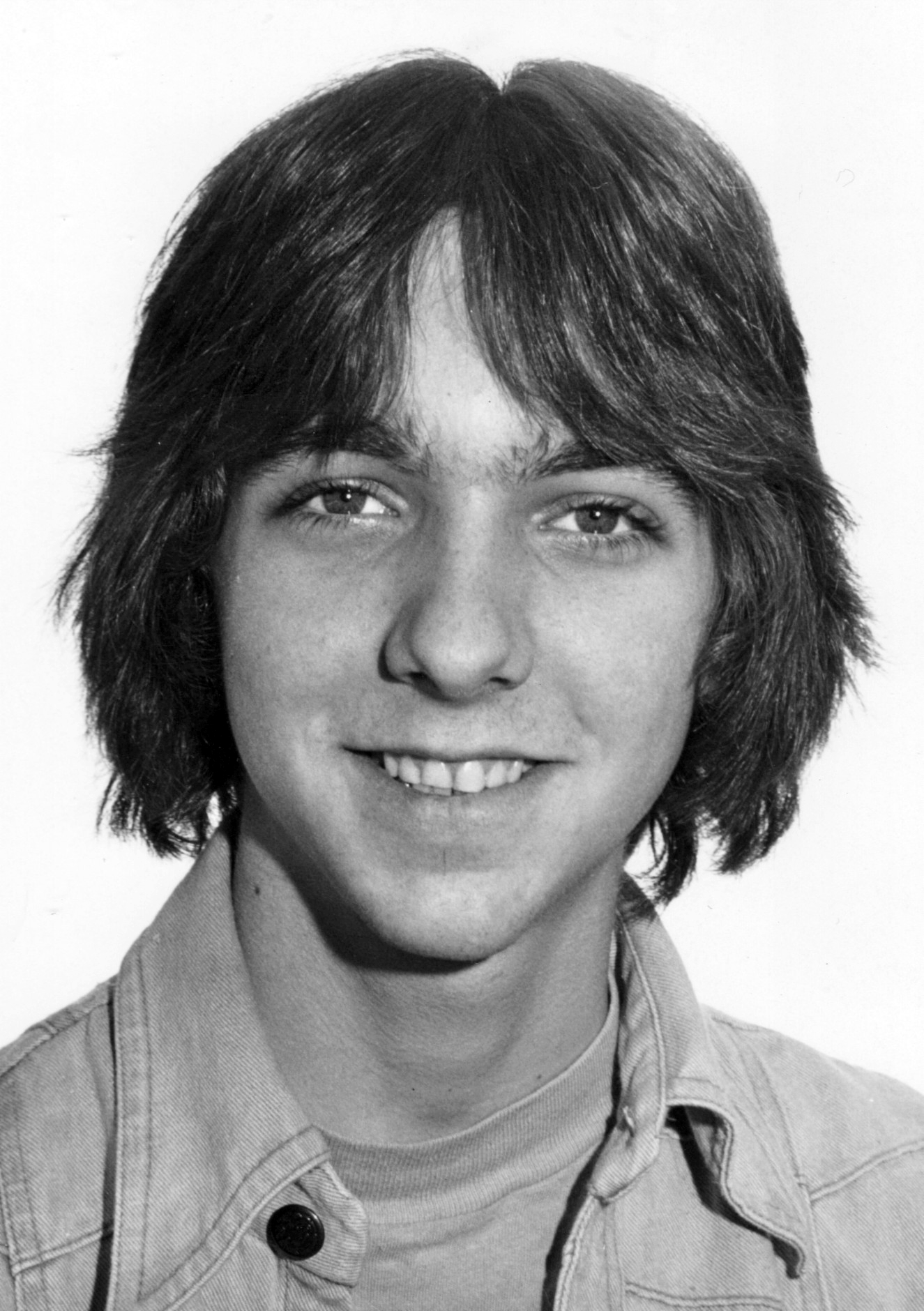 an older man in a jacket and on up shirt smiling