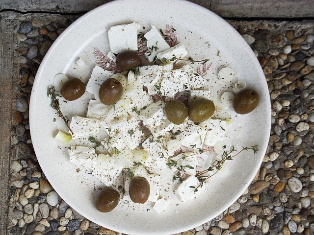 a plate topped with olives, cheese and pickles