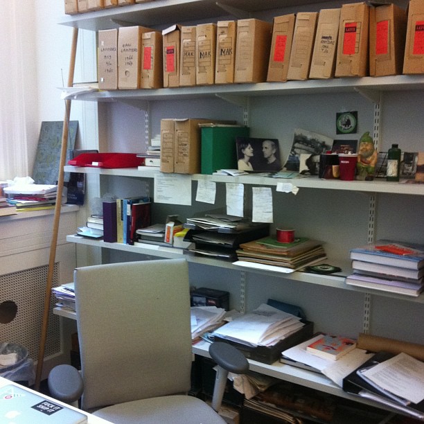 many books are neatly arranged around a computer desk