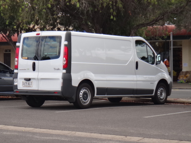 a white van parked in a parking lot next to another white car