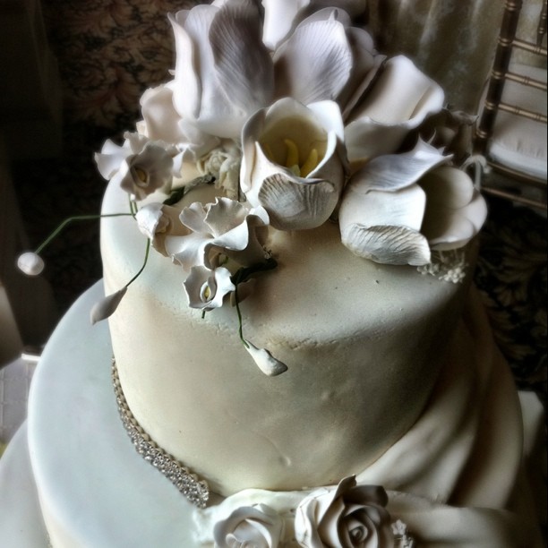 a white cake covered with many flowers and chains