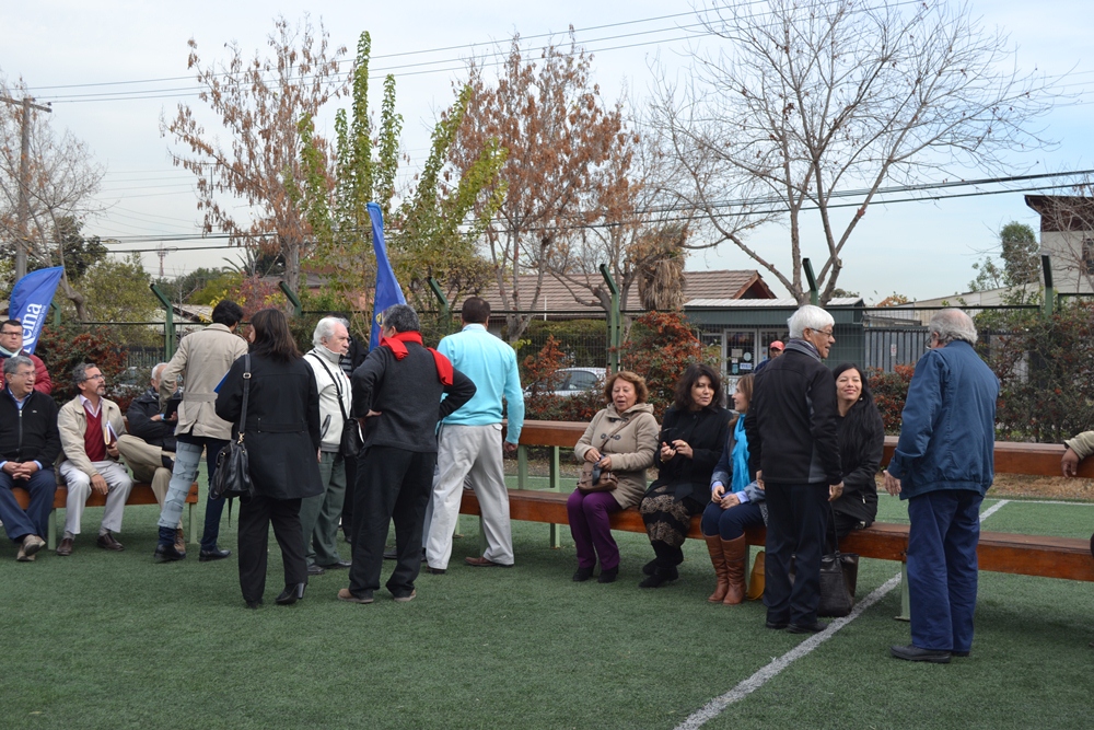 people stand around in front of a group of fenced in