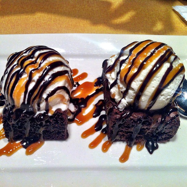 three chocolate cake desserts with ice cream, caramel sauce and drizzled
