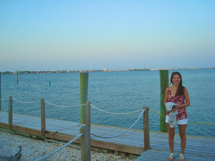 a woman standing on a wooden dock near the water