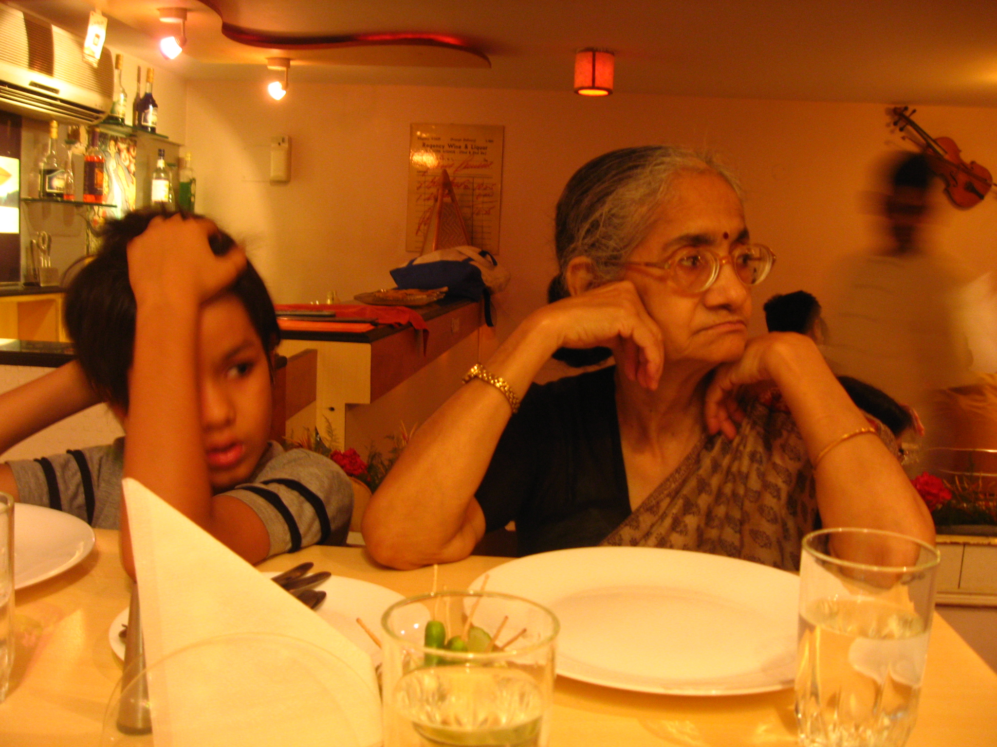 an older person sitting at a table with another person in front of them