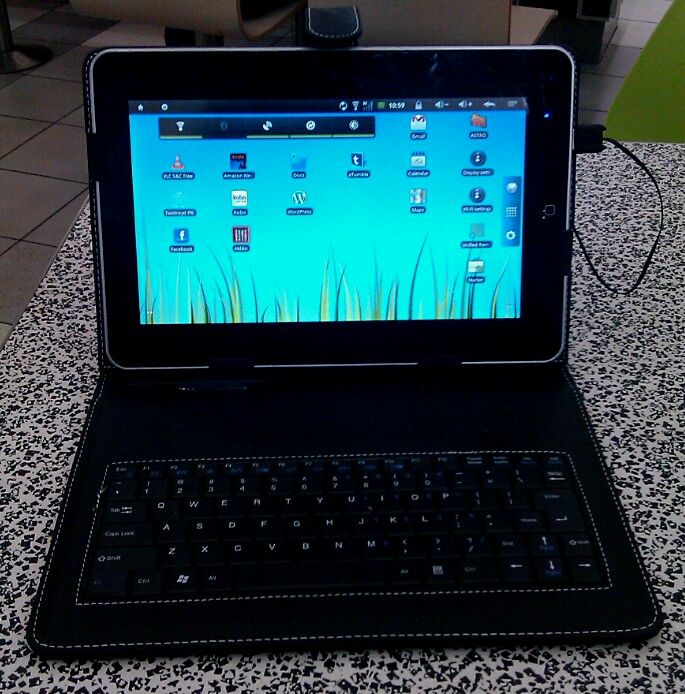 a tablet is next to a keyboard on a table