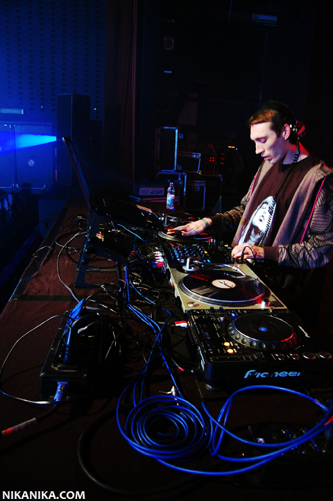 a man in black with headphones playing some electronic items