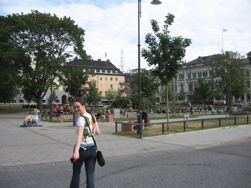 a woman walking down the street near a street light