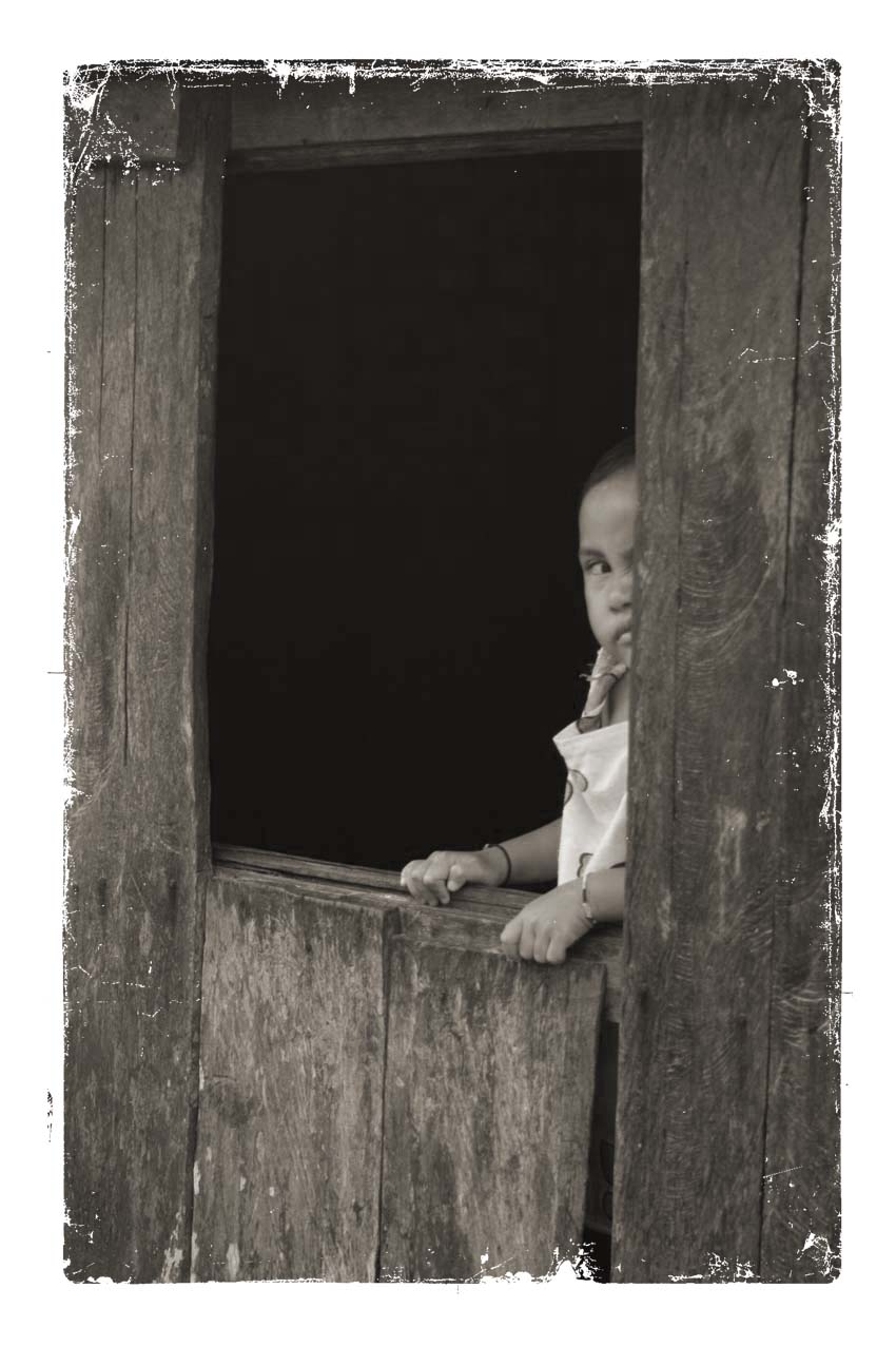 a young baby looks out the window from his home