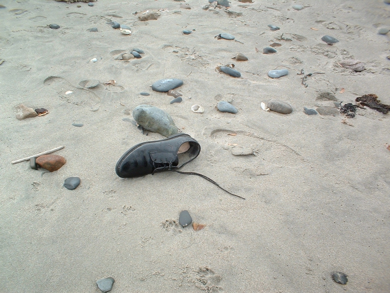 black sand with stones and an open shoe