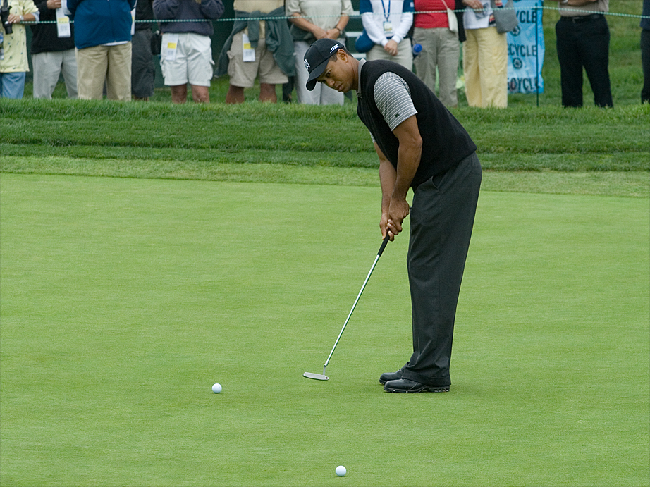 a man on a golf putting green with a ball in the grass