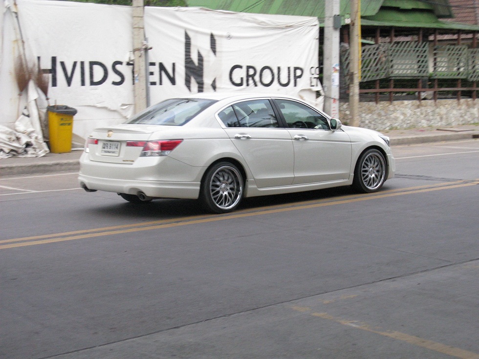 white car moving through the street near advertising banner