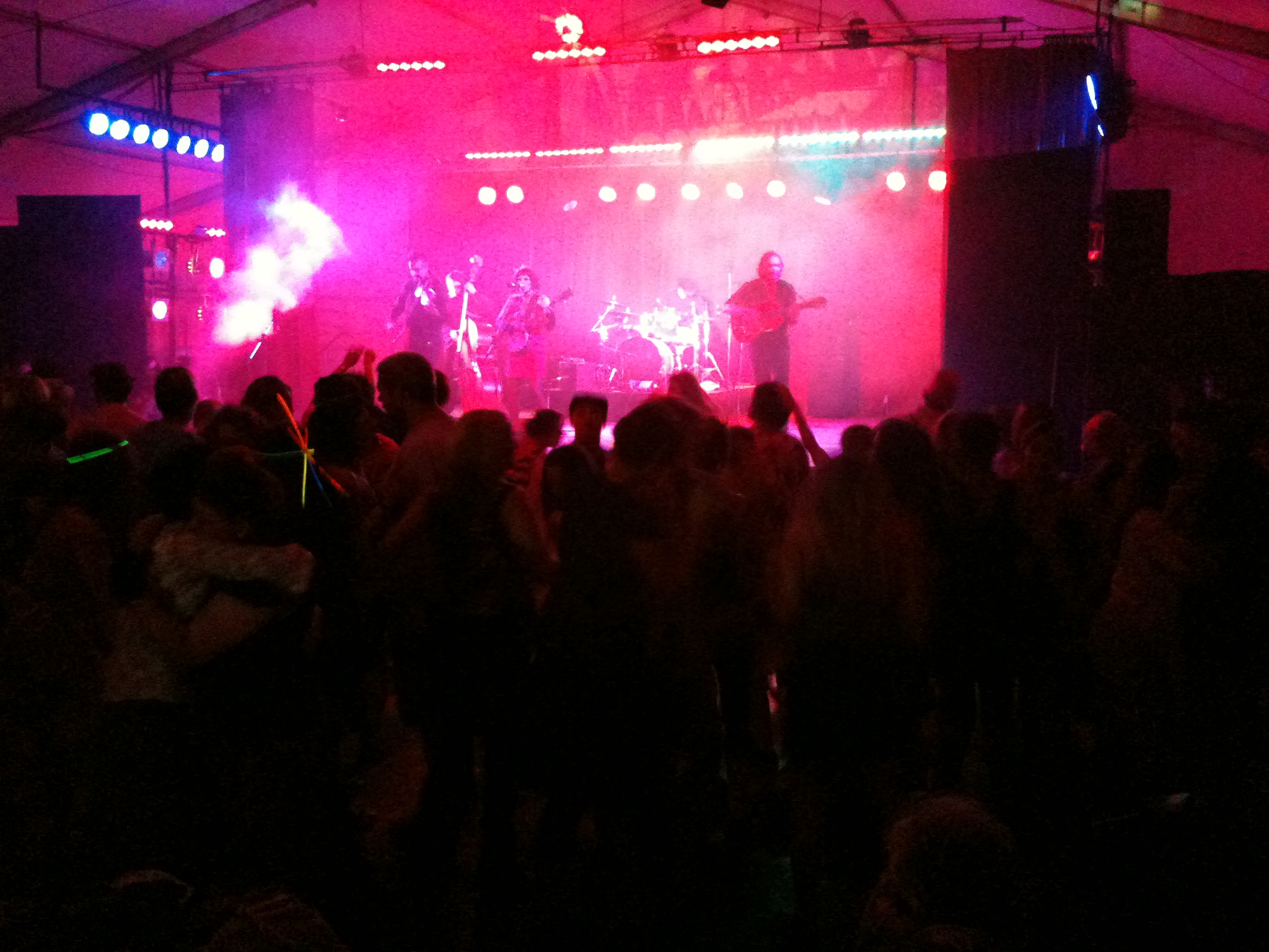 a group of people are gathered in front of stage lights