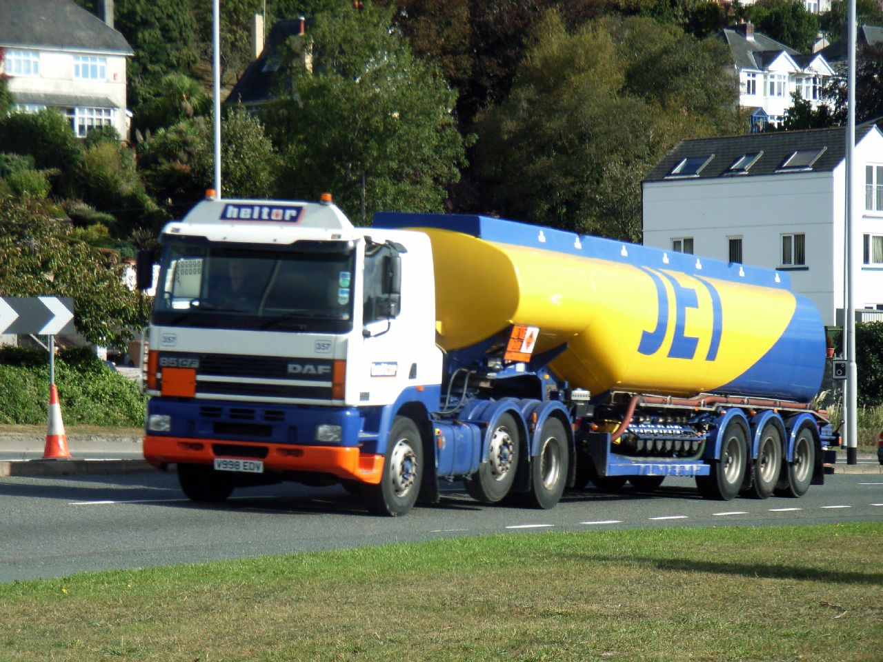 a semi truck hauling a large yellow and blue container