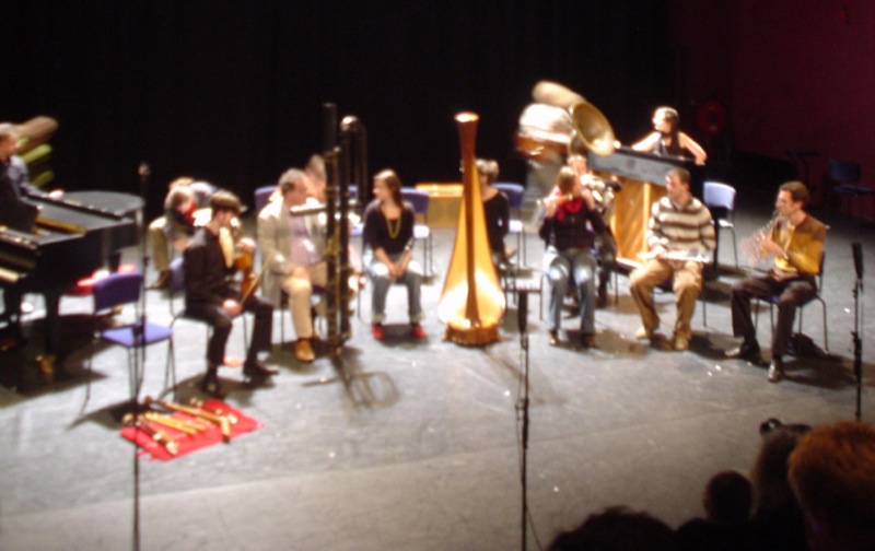 a band is performing on stage with instruments and harps