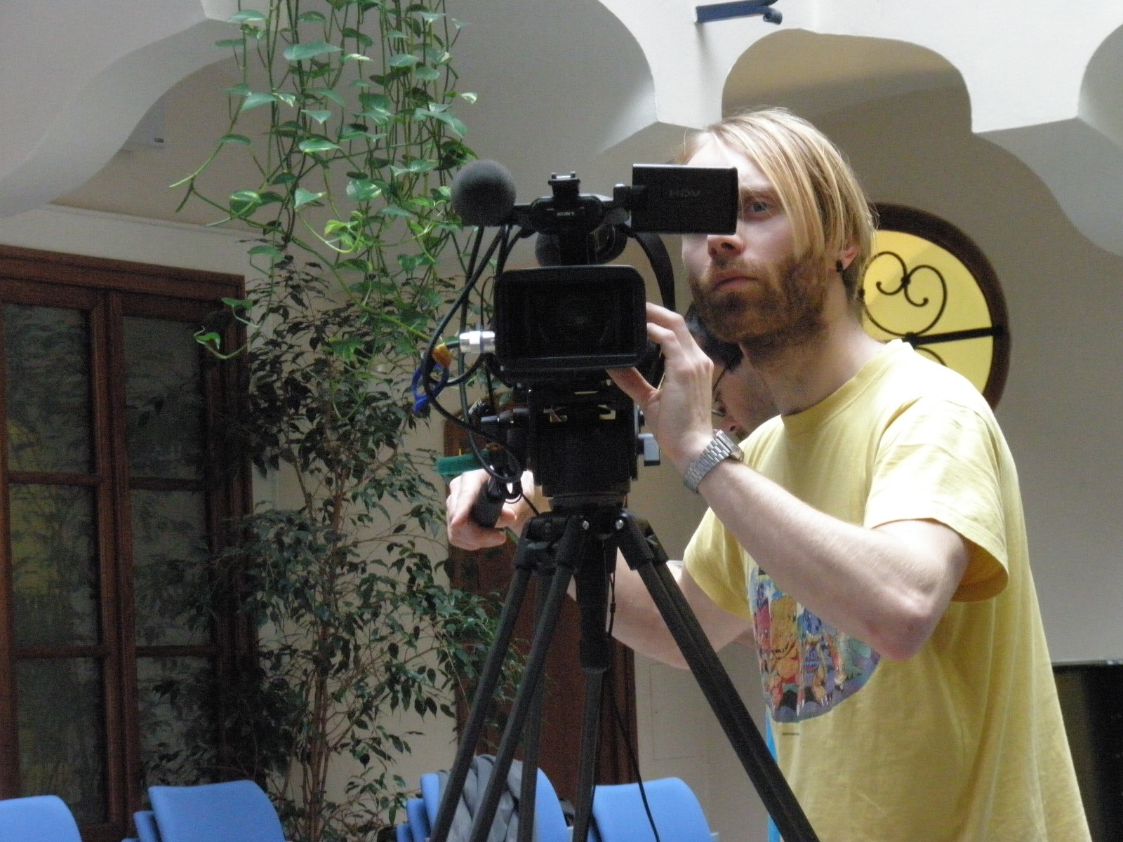 a man with long hair standing in front of a camera