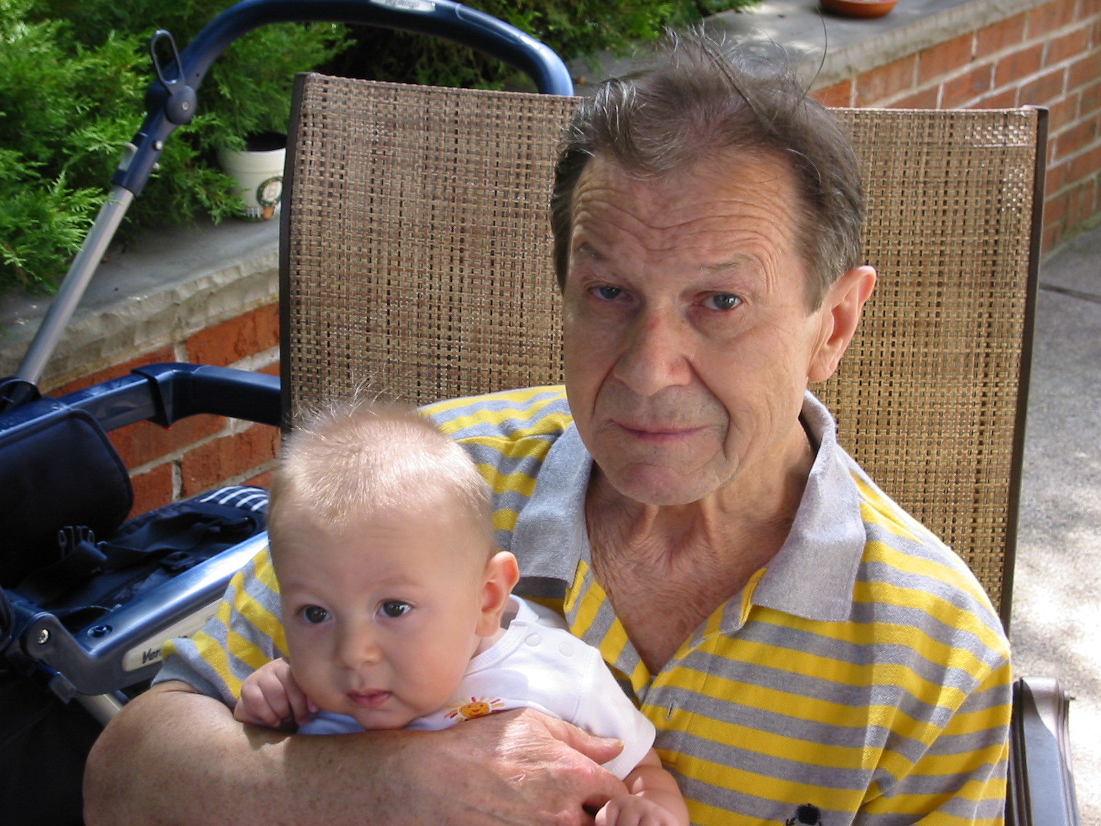 a man in striped shirt holding a baby