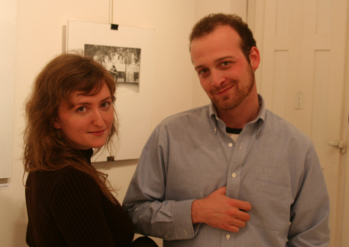 a man and a woman standing together, looking at the camera