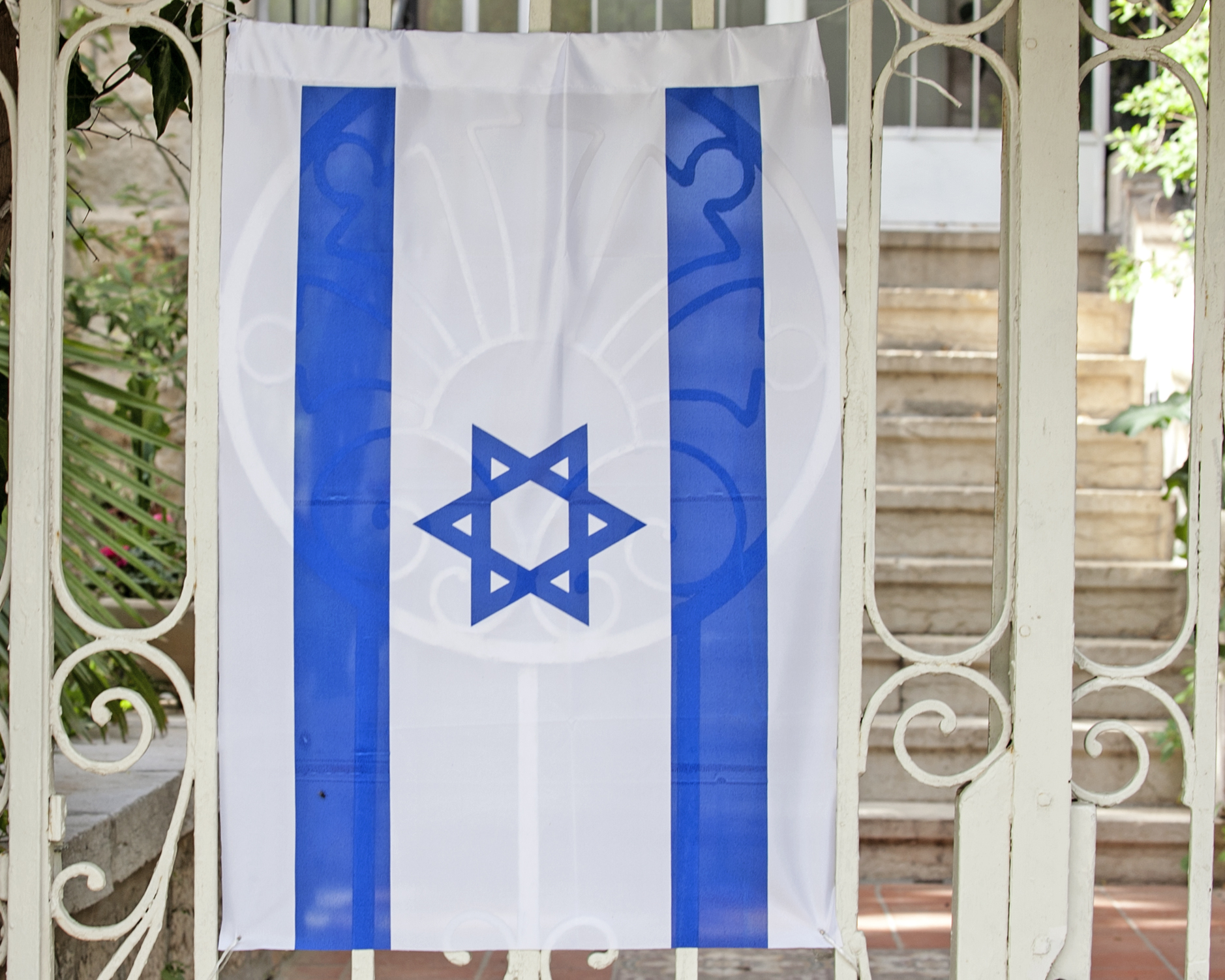 a large jewish flag hanging from a fence