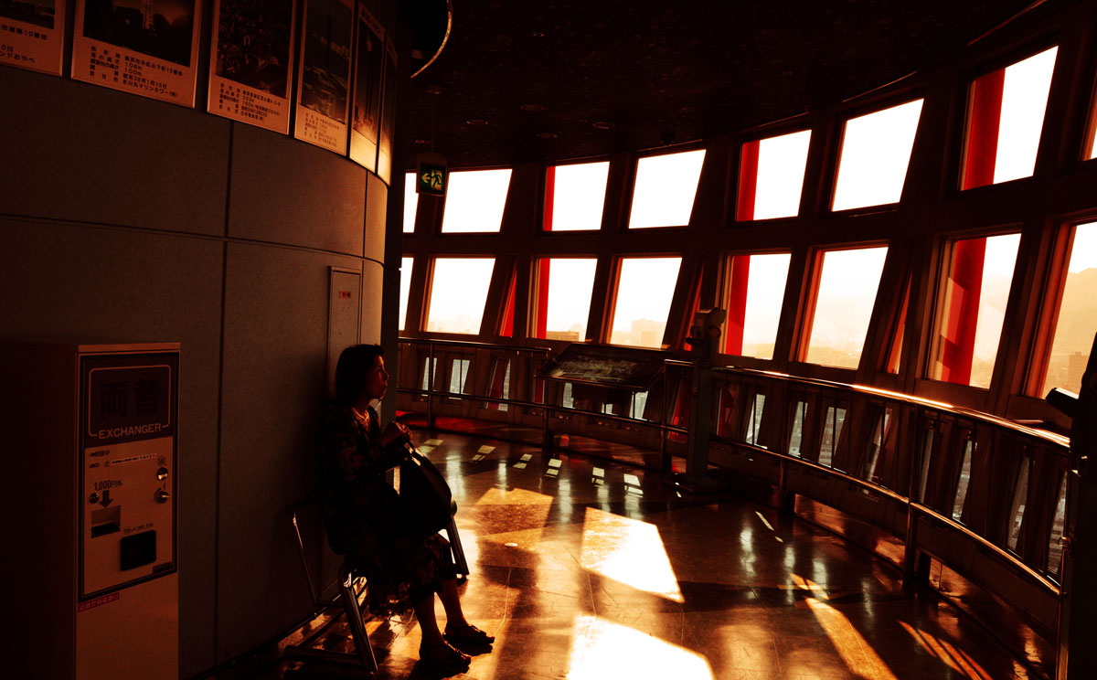 a person standing in an empty room with sunlight streaming through the windows