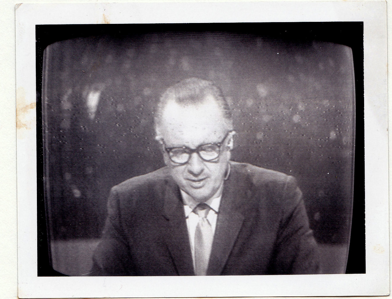 a black and white po of a man wearing glasses and suit