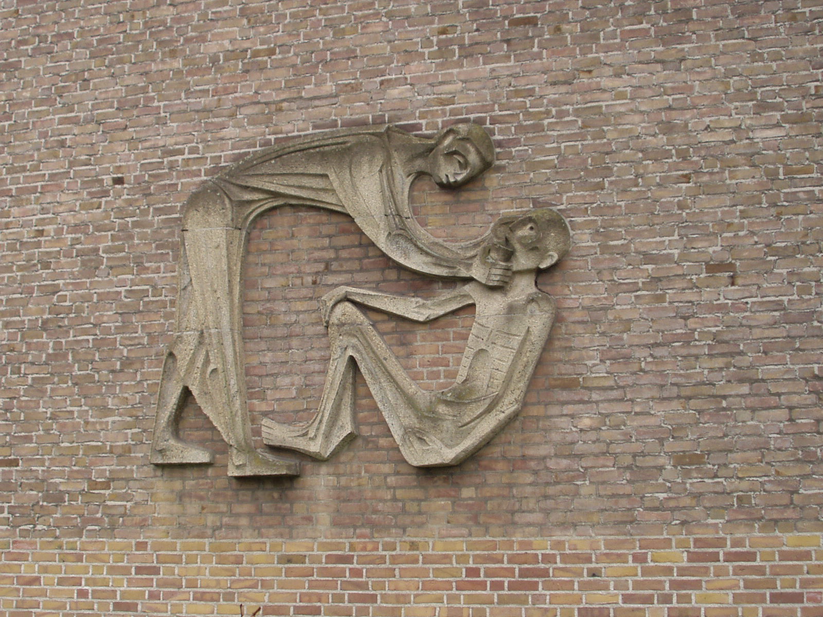 a statue is hanging on a brick wall