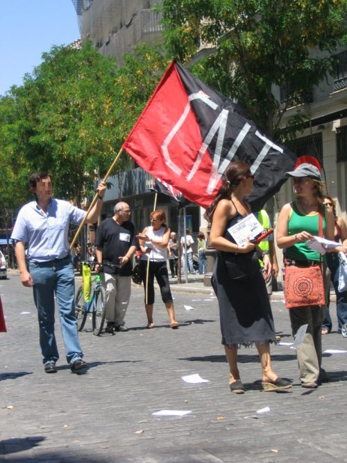 two women carrying an n y flag in a crowd